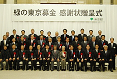 写真: (最前列左から7番目) 前田東京都副知事 (2列目右から2番目) KDDIプロダクト品質管理部長 藤山 尚紀